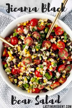 a white bowl filled with black beans, corn and tomatoes