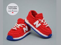 pair of red and white crocheted shoes on grey background