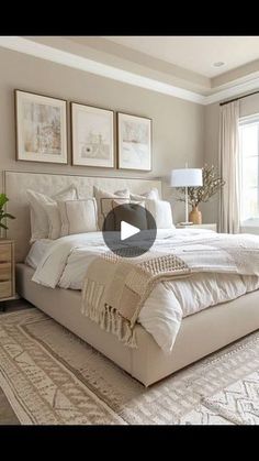 a large white bed sitting in a bedroom next to a window with pictures on the wall