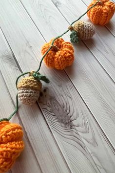 crocheted pumpkin garland on white wood background