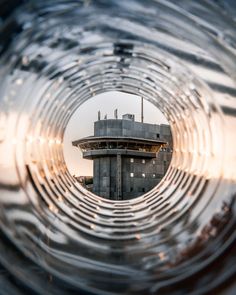 the inside of a glass tube with an observation tower in the background, seen through it