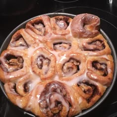 a pan filled with cinnamon rolls covered in icing