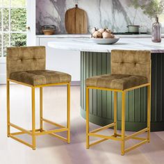 two stools sitting in front of a counter top with an art work on the wall behind them