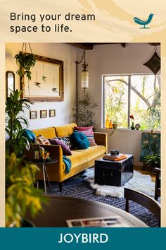 a living room with yellow couches and plants in the corner, and an advertisement for joybird furniture