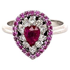 This ring has a Pear Cut Ruby that measures at approximately 6 mm x 4 mm. It also has 24 Round Cut Pink Sapphires that weigh 0.37 carats and there are 10 Round Cut Diamonds that weigh 0.28 carats. (Clarity: VS, Color: H) The total carat weight of the ring is 1.27 carats. The ring is curated in 14 Karat White Gold and weighs approximately 4.9 grams. It is a ring size 7 and can be re-sized if needed, free of charge. White Gold Engagement Ring, White Gold Engagement, White Gold Engagement Rings, Gold Engagement Ring, Gold Engagement, Gold Engagement Rings, Sapphire Diamond, Pear Cut, Jewelry Rings Engagement