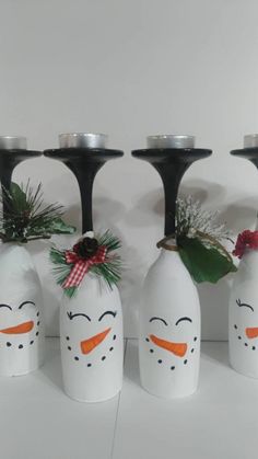 four snowman vases are lined up in front of each other