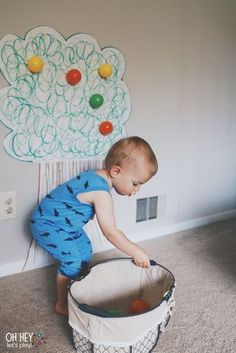 a young boy playing with a toy in a playpen on the floor next to a wall