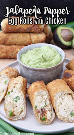 egg rolls with chicken and guacamole spread on a plate next to avocado