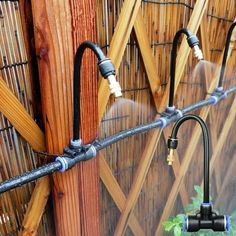 the hose is attached to the wooden fence and connected to the water sprinkler