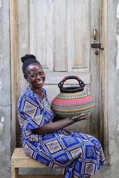 a woman sitting on a bench with a basket in front of her and smiling at the camera