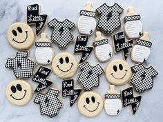 decorated cookies with black and white checkered designs are arranged on a marble table top