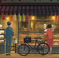 two people standing in front of a food stand with a bicycle parked next to it