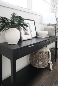 a black table with some plants and pictures on it