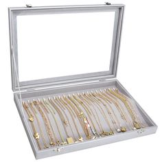 an open jewelry box filled with lots of gold necklaces