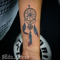 a small dream catcher tattoo on the wrist