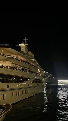 a large white boat in the water at night with lights on it's side