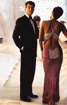 the man and woman are dressed up in evening wear, standing next to each other