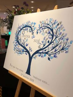 a white sign with blue leaves on it that says mimi noel, in the shape of a tree