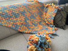 a crocheted blanket laying on top of a couch