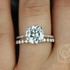 a woman's hand with a diamond ring on top of her finger and the engagement band