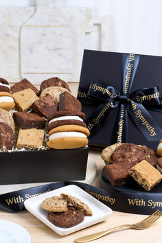 a box filled with cookies and desserts on top of a table next to a plate