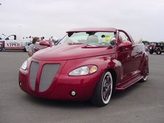 a red convertible car parked in a parking lot