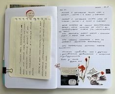 an open notebook with writing on it and flowers in the page next to it,