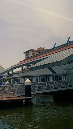 there is a boat docked at the dock in front of some buildings and umbrellas