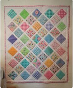 a colorful quilt hanging on the wall