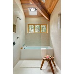 a bathroom with a tub and wooden ceiling