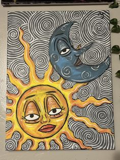 the sun and moon are depicted in this art work, which is hanging on the wall