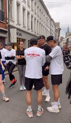 a group of people standing around each other in the street