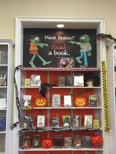 a book shelf with books and halloween decorations