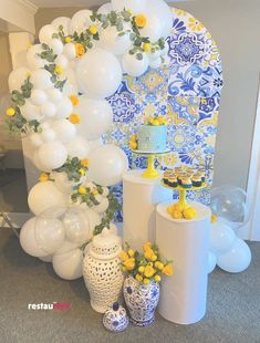 balloons and flowers are on display in front of a blue and white backdrop with yellow flowers