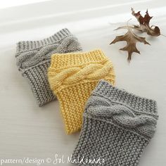 three knitted headbands sitting on top of a table next to an oak leaf