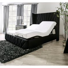 an image of a bed that is in the middle of a room with black furniture