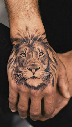 a man's hand with a lion tattoo on it