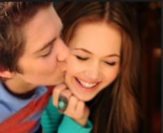 a young man and woman kissing each other