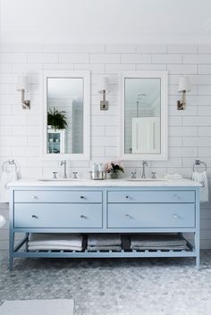 a bathroom with two sinks and mirrors on the wall