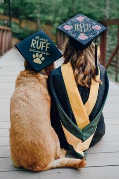 a dog wearing a graduation cap and gown sitting next to a cat on a deck