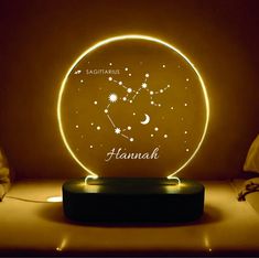 an illuminated lamp with the zodiac sign and stars on it, sitting on a table