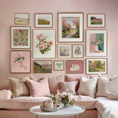 a living room filled with lots of pink furniture and pictures on the wall above it