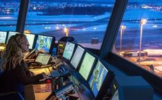 a woman sitting at a control desk in an airport