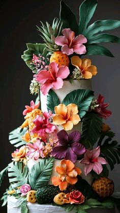 a three tiered cake decorated with flowers and leaves