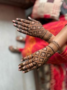 a woman's hands with henna tattoos on them