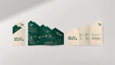 three folded brochures are displayed on a white surface with green and beige designs