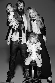 a man, woman and child are posing for a black and white photo in the studio