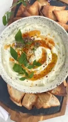 a plate with hummus and herbs on it