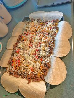 an uncooked pizza sitting on top of a pan covered in cheese and other toppings