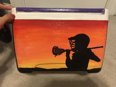 a hand painted lunch box with a silhouette of a person holding a baseball bat